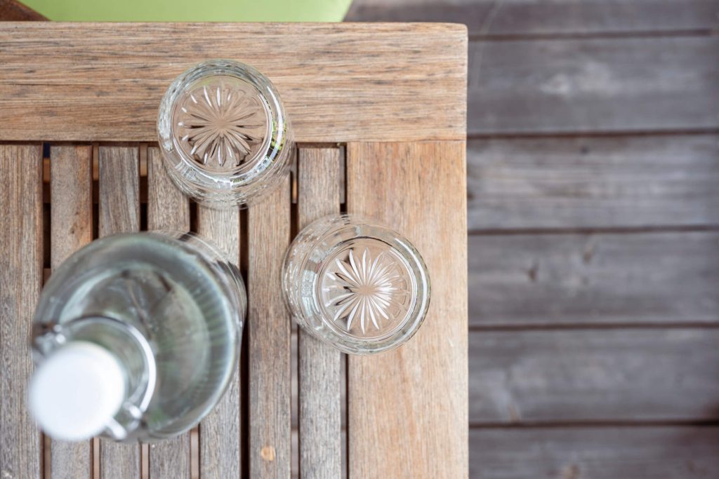 Glass bottles and glasses on a wooden tray, matching the relaxing ambience in Hotel Lärchenhof.
