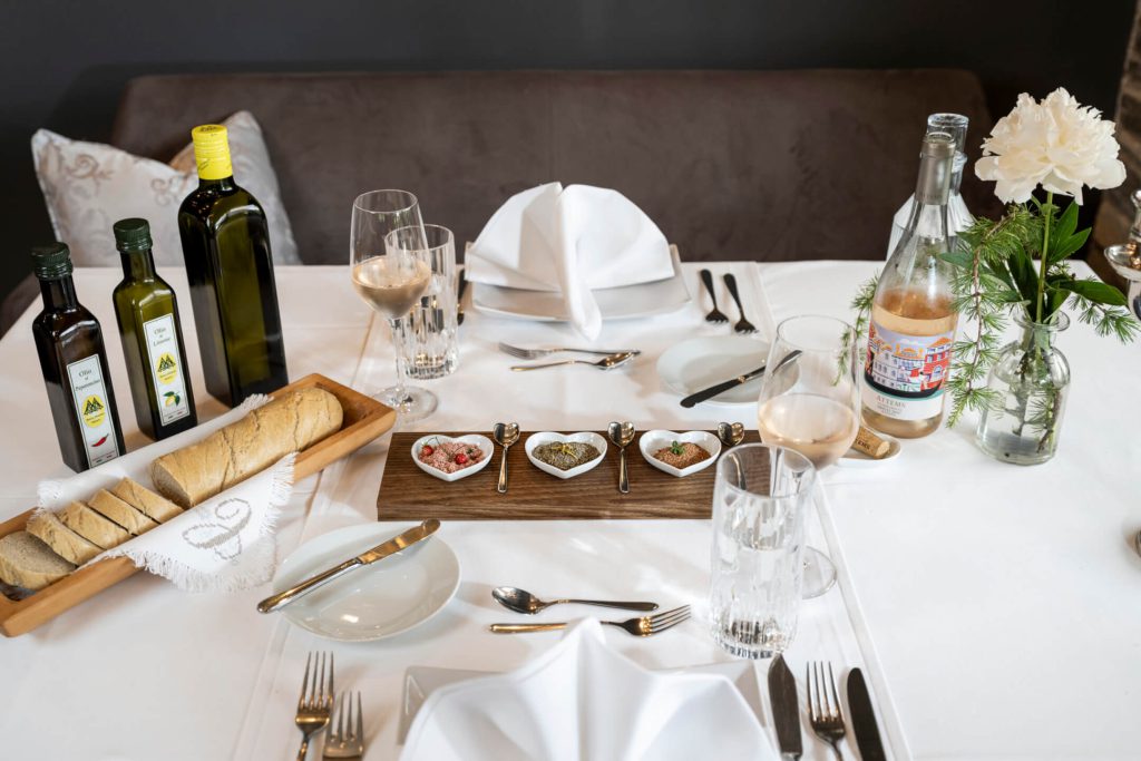 Elegantly set table with olive oil, bread, wine and fine spices at Hotel Lärchenhof.