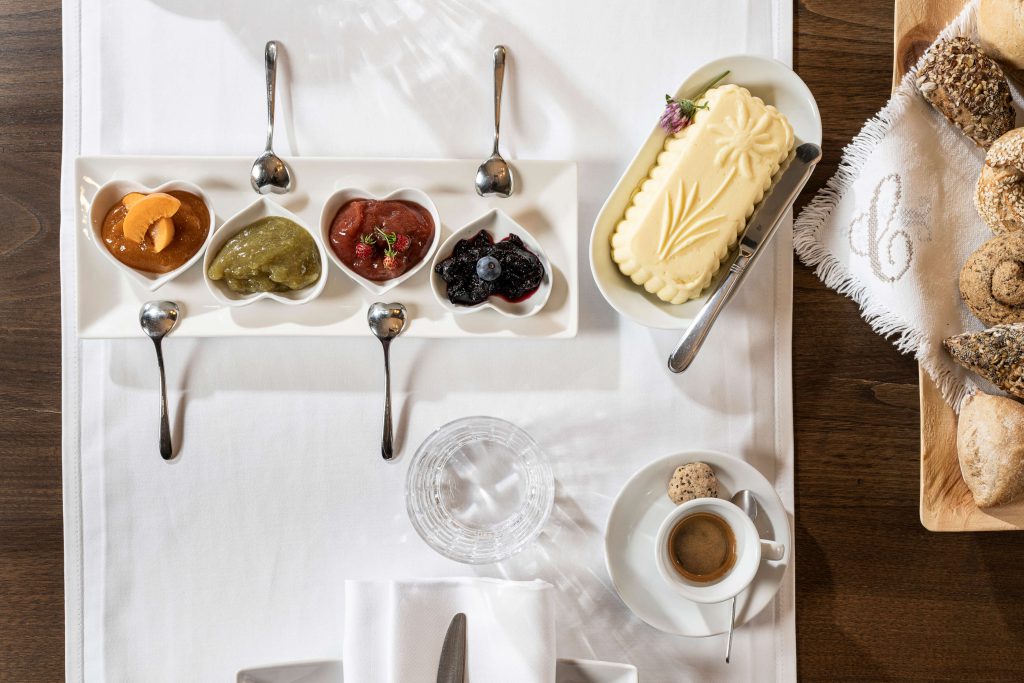 A variety of delicacies in heart-shaped bowls, served alongside bread and coffee.