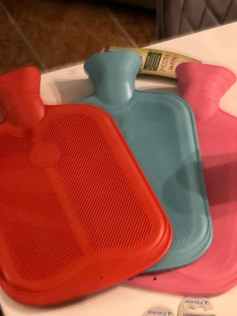 Drei bunte Wärmflaschen auf einem Tisch
